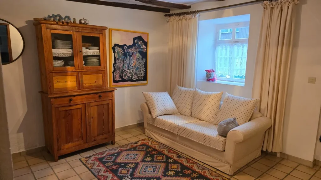 Wohnzimmer mit Sofa und alter Vitrine