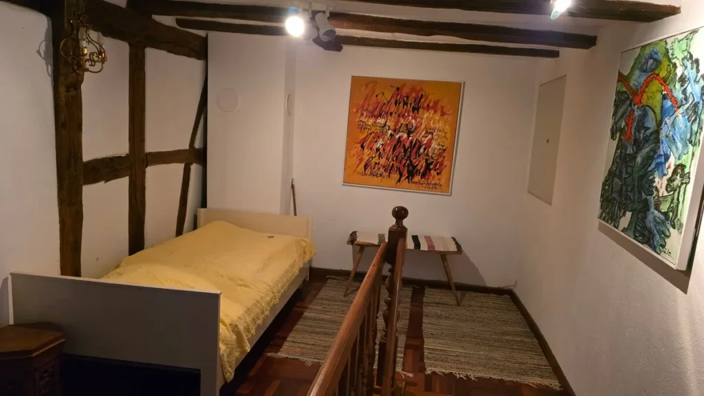Schlafzimmer mit Bildern an der Fachwerkwand