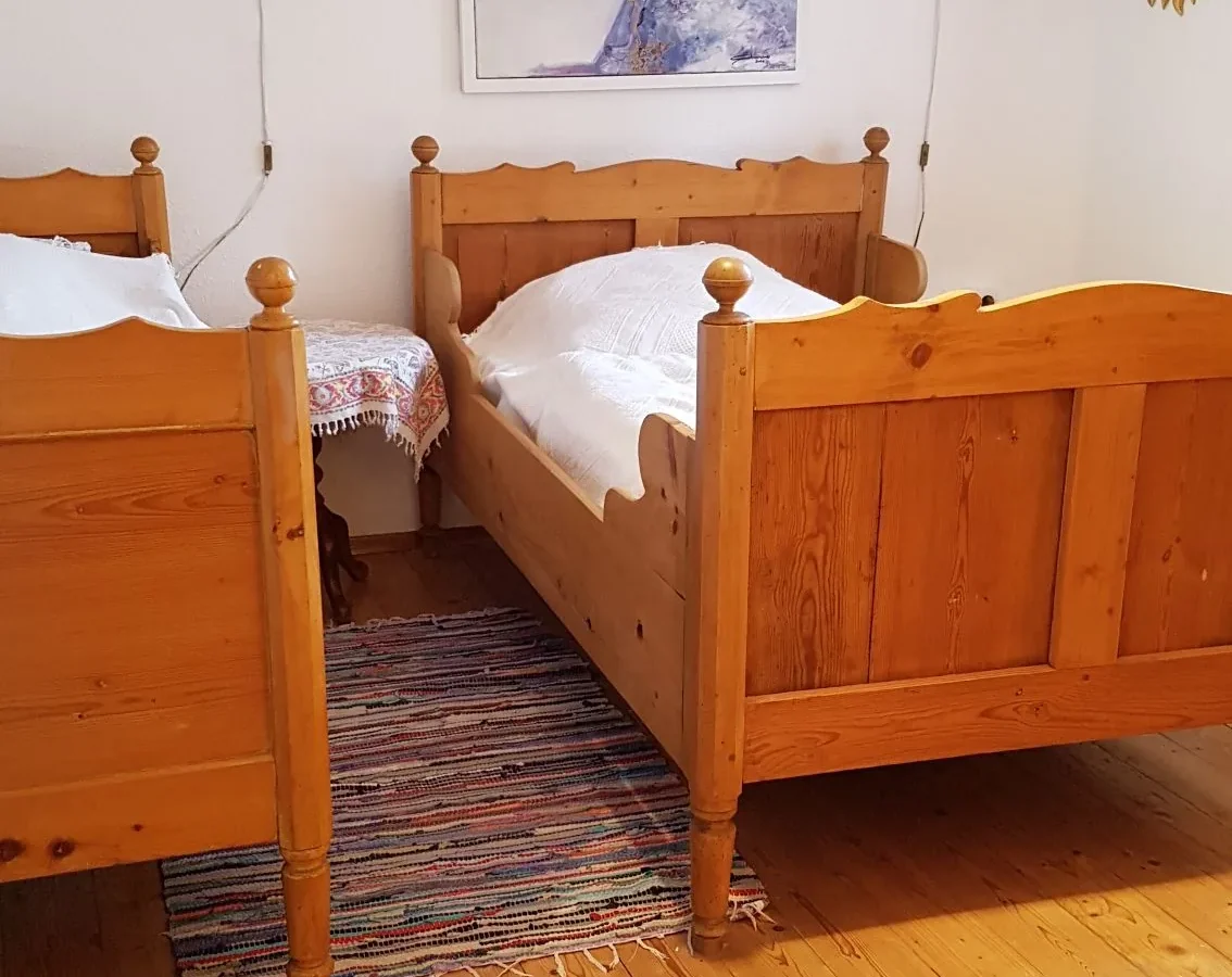 Schlafzimmer mit Holzbetten und Dielenboden